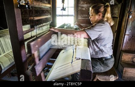 Park ranger demonstrates the use of a hand loom to make cloth, Mabry Mill, Blue Ridge Parkway, Virginia, USA Stock Photo