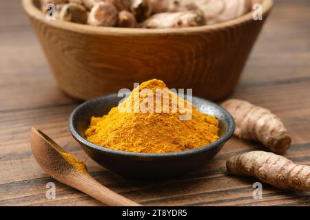 Turmeric spice. Curcuma powder seasoning and whole turmeric roots. Stock Photo