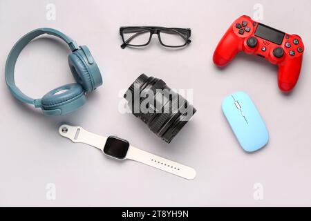 Modern gadgets with eyeglasses on light background Stock Photo