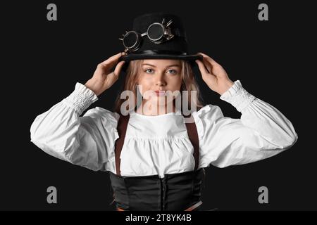 Young woman with steampunk goggles on dark background Stock Photo
