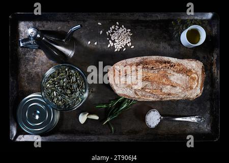 Composition with bread, pumpkin seeds and olive oil on baking tray Stock Photo