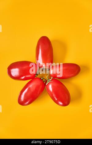 Composition of five star-shaped tomatoes on a yellow background Stock Photo