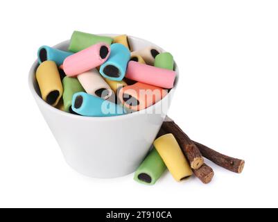 Bowl with many tasty candies and dried sticks of liquorice root isolated on white Stock Photo