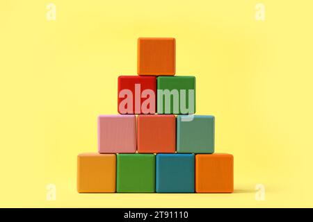 Pyramid of blank colorful cubes on yellow background Stock Photo