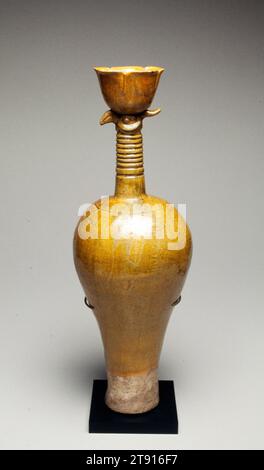 Phoenix-Head Ewer, 10th-13th century, 19 1/2 x 6 3/4 in. (49.5 x 17.15 cm), Stoneware with yellow glaze over a white slip, China, 10th-13th century, Ceramic shapes of the Liao dynasty (907-1125) generally have their antecedents in the wares of the Five Dynasties (906-960) and Northern Song (960-1127). The long necked vase with an exaggerated tapering body was, however, a purely Liao form. Found in Inner Mongolia and Liaoning Province, these vases are usually glazed in white, yellow, or green and have a simple trumpet -shaped mouth. This phoenix-head vase is a typical hybrid example. Stock Photo
