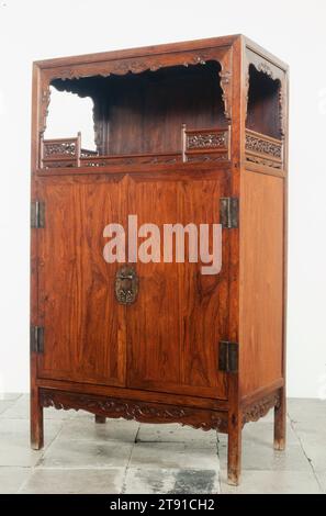 Display Cabinet, one of a pair, 18th century, 74-5/16 x 43 x 24-9/16 in. (188.8 x 109.2 x 62.4 cm), Huanghuali hardwood, China, 17th century, There are very few Ming-style cabinets made specifically for the storage and display of art. This classic pair features decorative inner frames and railings surrounding the open shelves. Precious huanghuali hardwood has been used throughout, including the backs, shelves, tops, and bottoms of these luxurious storage units. Cabinets of this type have a high, open shelf on which to display antiques or decorative objects. Stock Photo