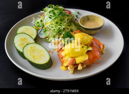white plate with eggs bennedict waffles with smoked salmon on a white background Stock Photo
