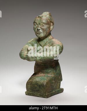 Kneeling figure, 4th century BCE, 11 1/4 × 6 × 6 in., 7.3 lb. (28.58 × 15.24 × 15.24 cm, 3.3 kg), Bronze, China, 4th century BCE, Excavated near Luoyang, the capital of the Eastern Zhou dynasty (770–256 BCE), this small sculpture of a kneeling man holding a tube-like vessel in his extended hands may have served as a torch bearer in a tomb. The figure is clothed in a close-fitting garment that wraps from left to right and is belted with a narrow band. The head covering, rather like an open helmet, is broad at the back and rises to a peaked top before descending in a narrow tongue-shaped band Stock Photo