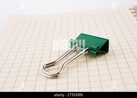 Colored paper clip on a checked notebook page Stock Photo