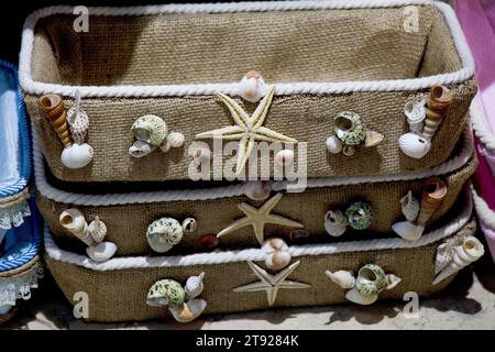 Various types of little seashells and starfish on the face of the basket Stock Photo