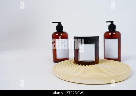 Body care. two bottles with a dispenser and a jar of body cream on a geometric stand on a light gray background. Advertising concept Stock Photo