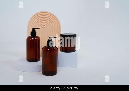 Composition with geometric shapes.body care. two bottles with a dispenser and a jar of cream, on a light gray background. Advertising concept Stock Photo