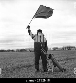Hare Coursing 2000s UK. On a bitterly cold February day members of the Swaffham Coursing Club meet near Narborough, Norfolk. The judge on horseback monitors each course. He carries with him a small red and white flag, which he waves to indicate to the flagman which greyhound has won. The flagman then flies the appropriate coloured flag. England 2000s HOMER SYKES Stock Photo