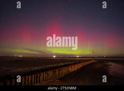 Wangerland, Germany. 22nd Nov, 2023. Northern lights shine over the beach at Hooksiel in the district of Friesland. Credit: Markus Hibbeler/dpa/Alamy Live News Stock Photo