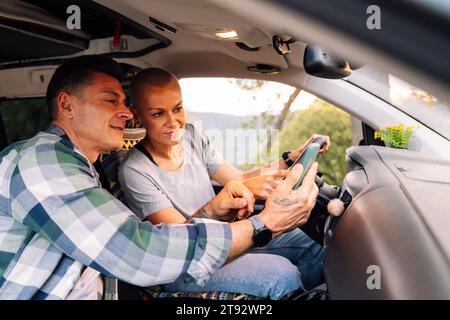couple planning on phone the route in camper van Stock Photo