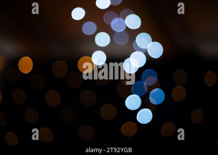 Immerse yourself in the enchanting ambiance of this festive bokeh background adorned with delicate light blue and dark gold circles and ovals. Against Stock Photo