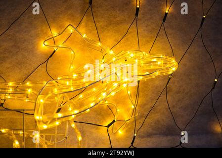 Illuminate your designs with the captivating charm of a reindeer head outlined by warm golden lights. Against a sleek black background, the details of Stock Photo