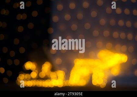 Immerse yourself in the enchanting atmosphere of this festive bokeh, captured with a 75mm lens on a full-frame camera. The image features a blurred ye Stock Photo