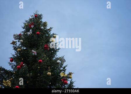 Immerse yourself in the enchantment of a majestic Christmas tree, standing tall and resplendent with radiant lights, red, golden, and silver ornaments Stock Photo