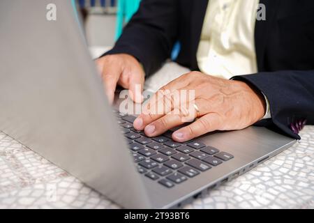 Unrecognizable businessman with a suit typing on laptop keyboard outside Stock Photo