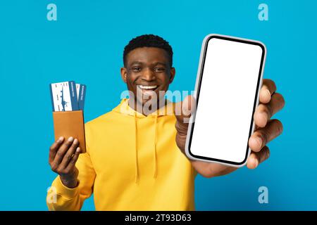 Excited black man hold passport ticket use mobile cell phone Stock Photo