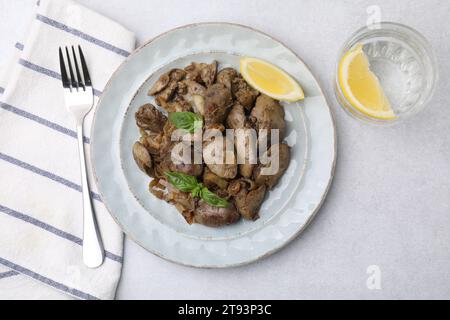 Delicious fried chicken liver with onion served on light table, flat lay Stock Photo