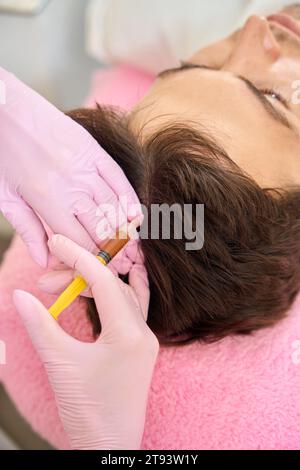 Doctor gives injections to the clients scalp Stock Photo