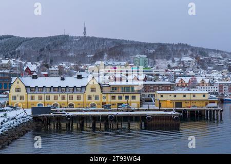 Buildings along waterfront harbour in the snow at Harstad, Norway, Scandinavia, Europe in October Stock Photo