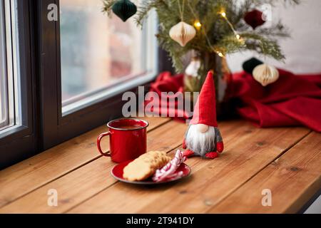 christmas gnome, coffee and cookies on window sill Stock Photo