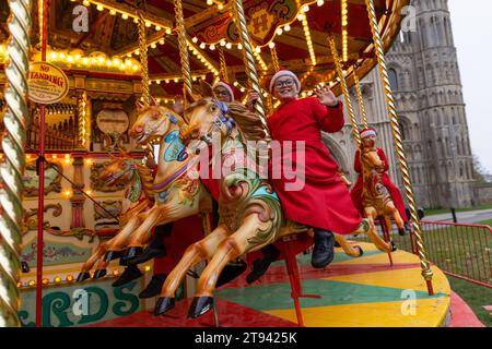 Choristers from Ely Cathedral  going for a spin on the  traditional carousel at the city’s Christmas market  after early morning choir practice . Stock Photo