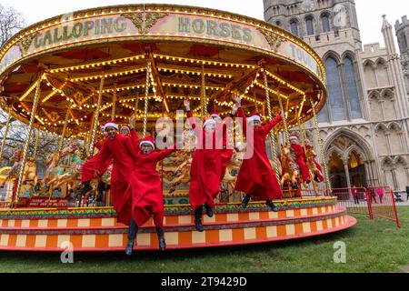 Choristers from Ely Cathedral  going for a spin on the  traditional carousel at the city’s Christmas market  after early morning choir practice . Stock Photo