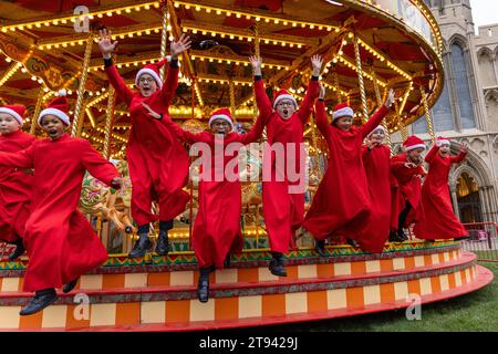 Choristers from Ely Cathedral  going for a spin on the  traditional carousel at the city’s Christmas market  after early morning choir practice . Stock Photo