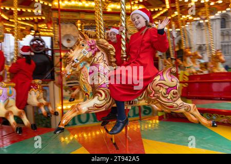 Choristers from Ely Cathedral  going for a spin on the  traditional carousel at the city’s Christmas market  after early morning choir practice . Stock Photo