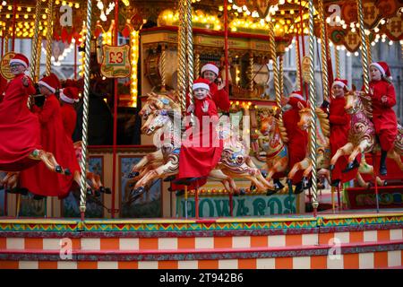 Choristers from Ely Cathedral  going for a spin on the  traditional carousel at the city’s Christmas market  after early morning choir practice . Stock Photo