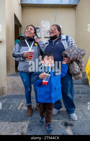 Viacha, La Paz, Bolivia – August 16, 2022: Bolivian Women and a Boy with Masks Hang Out in the Street and Drink Juice Stock Photo