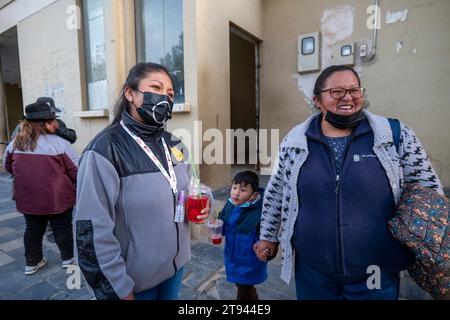 Viacha, La Paz, Bolivia – August 16, 2022: Bolivian Women and a Boy with Masks Hang Out in the Street and Drink Juice Stock Photo