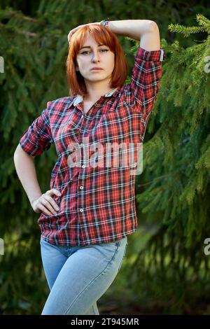 A redhead woman poses gracefully in the warm glow of an autumn sunse Stock Photo