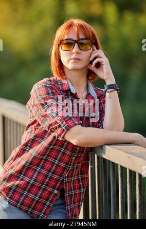 A redhead woman poses gracefully in the warm glow of an autumn sunset Stock Photo