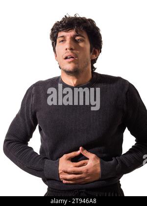 A young man is suffering from belly-ache, stomach ache, in a black sweater and black pants Stock Photo