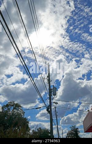 Power lines against a beautiful fall sky with puffy white clouds. Stock Photo