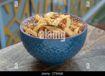 Spicy Stir-fried Pork belly with Preserved Bamboo shoot in ceramic bowl on wooden table. Space for text, Selective focus. Stock Photo