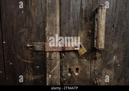 old iron lock with a padlock on weathered wooden door in Raca Monastery, Serbia Stock Photo