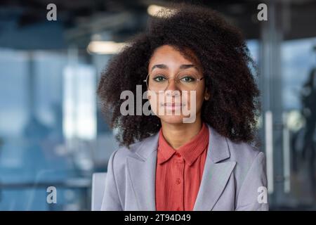 Close-up portrait of a young African American female student sitting on a university campus and looking seriously at the camera. Stock Photo