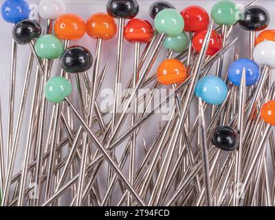 Background from sewing pins with multi-colored round heads on a light background Stock Photo