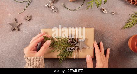 Christmas decor and Womans hands decorating handmade gift box Stock Photo