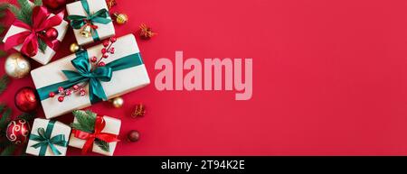 Holiday background with gift boxes and Christmas decorations. Christmas holiday red background. Top view with copy space. Stock Photo