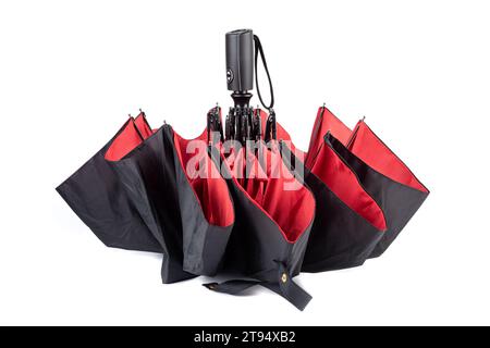 An umbrella with a black top and red bottom close-up on a white background. Copy space. Stock Photo