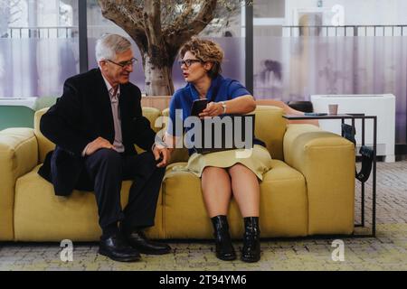 Cross generational, business pros work in a modern office. Collaborate, plan and share ideas for positive teamwork. Result: profitable company growth. Stock Photo