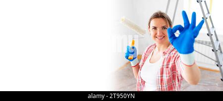Banner young smiling woman with roller brush showing ok gesture, copy space Stock Photo