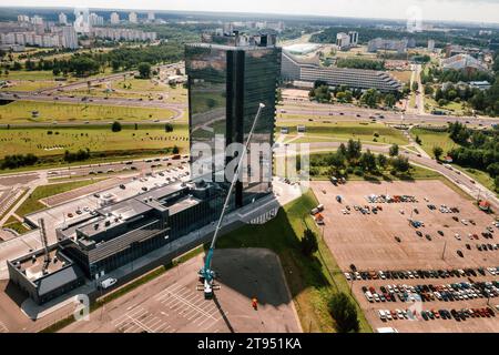 view from the height of the tallest car crane, which is open in the Parking lot near the glass building in the city and ready to work. the highest mob Stock Photo